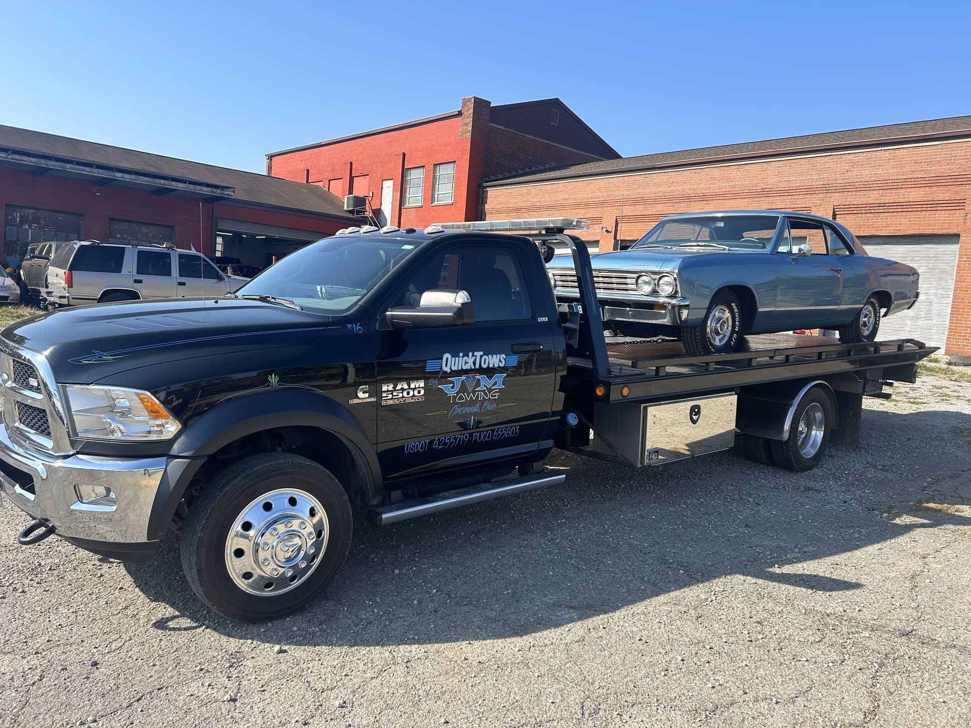 QuickTows truck towing a vehicle on a Cincinnati highway